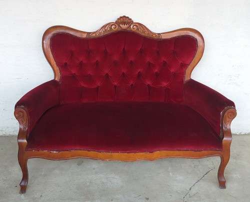 A lovely antique mid-century two-seater carved English Teak red velvet button-back sofa