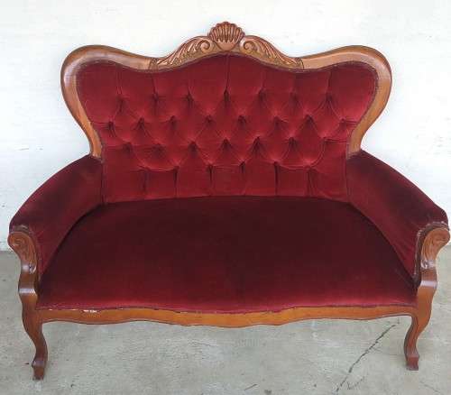 A lovely antique mid-century two-seater carved English Teak red velvet button-back sofa