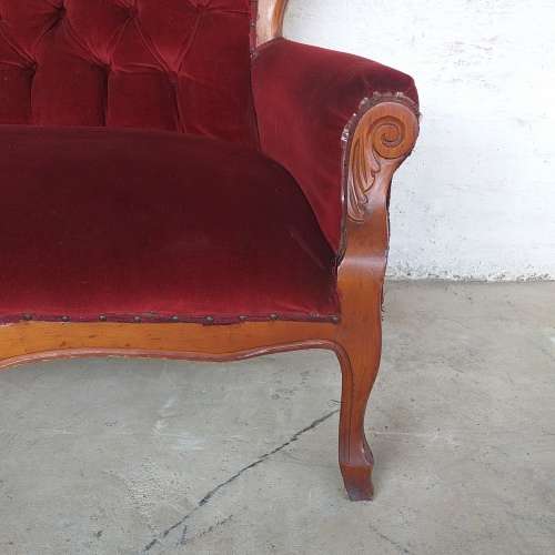 A lovely antique mid-century two-seater carved English Teak red velvet button-back sofa
