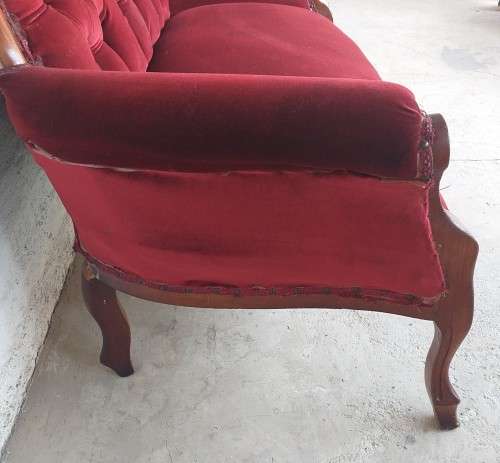 A lovely antique mid-century two-seater carved English Teak red velvet button-back sofa