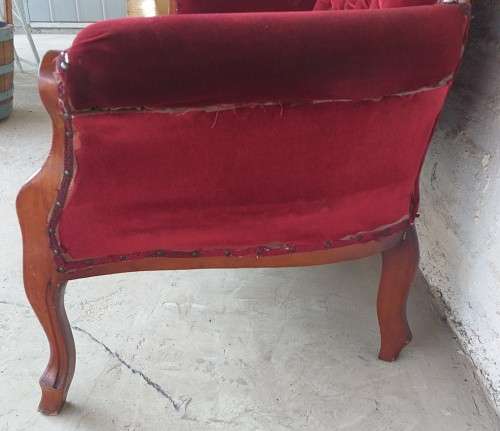 A lovely antique mid-century two-seater carved English Teak red velvet button-back sofa