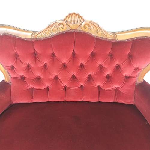 A lovely antique mid-century two-seater carved English Teak red velvet button-back sofa