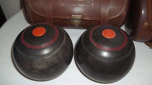 A WONDERFUL SET OF FOUR DUNLOP LAWN BOWLS IN TWO GENUINE LEATHER CARRY BAGS
