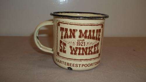 A FANTASTIC CREAM ENAMEL "TAN' MALIE SE WINKEL" COFFEE MUG - A GREAT COLLECTORS PIECE