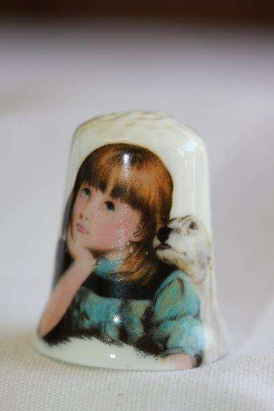 A STUNNING PORCELAIN/ FINE BONE CHINA THIMBLE OF A LITTLE GIRL DAYDREAMING