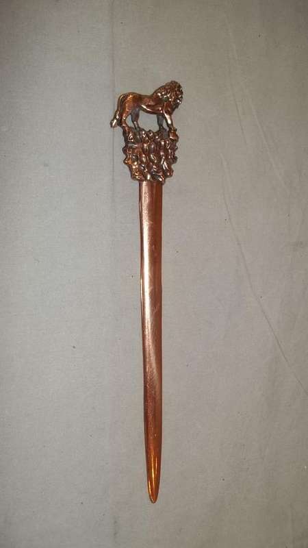 A STUNNING COPPER LETTER OPENER WITH A LION DECAL ON THE END OF THE LETTER OPENER