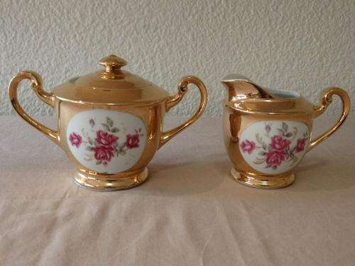 A STUNNING BONE CHINA MILK JUG AND SUGAR BOWL WITH A BROAD GOLD GILDED RIM AND DAINTY PINK FLOWERS