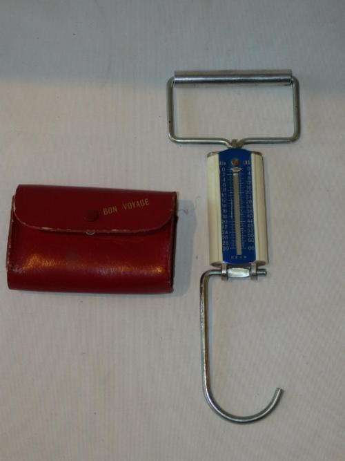 A FANTASTIC VINTAGE PORTABLE COMPACT TRAVEL LUGGAGE SCALE IN A RED LEATHER CASE - VERY UNUSUAL