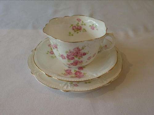 AN EXQUISITE AND VERY ELEGANT BONE CHINA TEA SET TRIO WITH GOLD GILDED RIMS AND PINK ROSE PATTERN