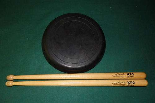 A FANTASTIC PAIR VIC FIRTH (JIM KILPATRICK) KP2  DRUMSTICKS WITH A DRUM PRACTICE PAD