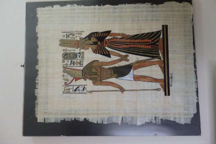 AN EXQUISITE EGYPTIAN THEMED PAPYRUS PAINTING PROTECTED BEHIND GLASS IN A FRAME-LESS FRAME