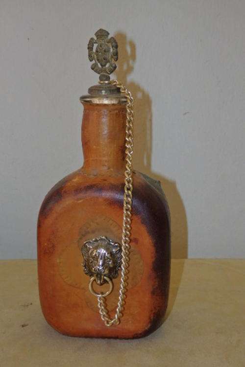 AN UNUSUAL ITALIAN MADE "LEATHER CLAD" GLASS LIQUEUR DECANTER WITH A LION HEAD DECAL