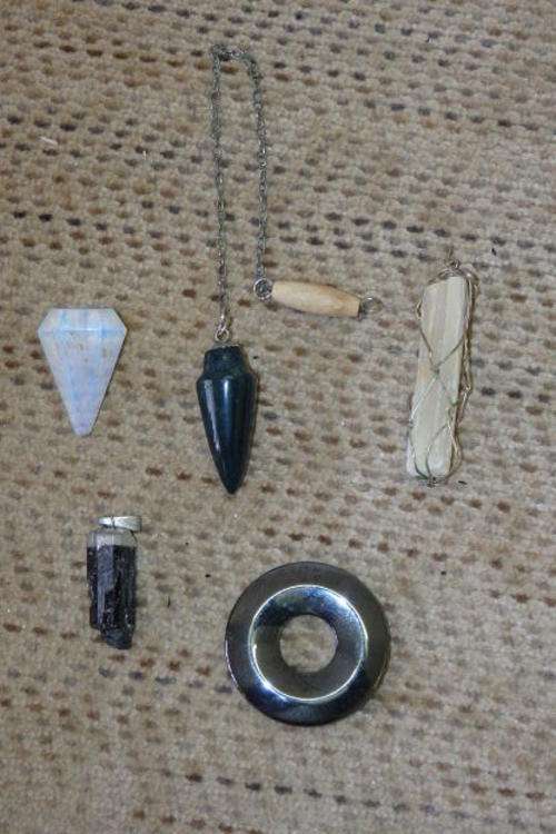 A STUNNING COLLECTION OF FIVE SEMI-PRECIOUS STONE PENDANTS INCLUDING ROCK CRYSTAL AND QUARTZ STONES