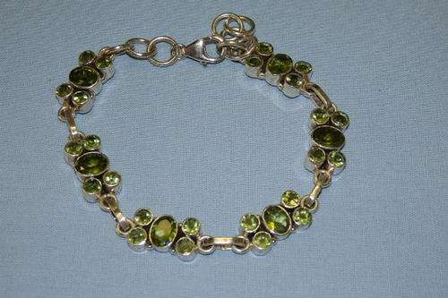 A STUNNING STERLING SILVER LADIES BRACELET WITH 30 INCREDIBLE PERIDOT STONES