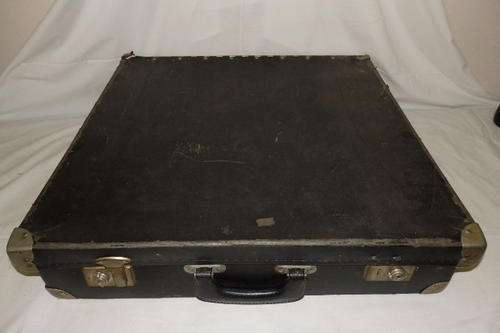 A LARGE BLACK VINTAGE SUITCASE WITH METAL CORNER CAPS AND A GREEN VELD LINING