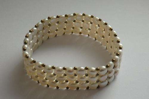 A STUNNING "TRIPPLE STRAND" "WHITE" GENUINE PEARL BRACELET ON AN ELASTICIZED STRAND