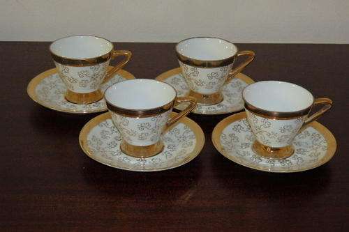 A BEAUTIFUL SET OF FOUR CRISP WHITE PORCELAIN DEMITASSE COFFEE CUPS WITH GOLD "SWIRL" DETAILING