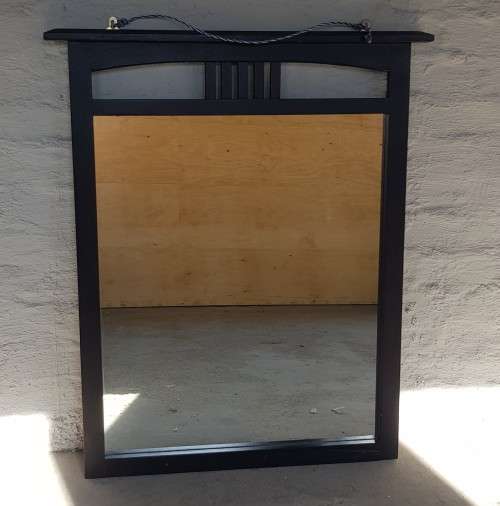 A vintage wall hanging mirror with a wood frame, great for above a basin or mantle