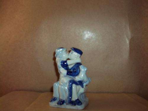 Porcelain figurines sitting on a bench 10.5cm high and 7cm wide