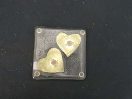 Glass coaster with brass hearts inside