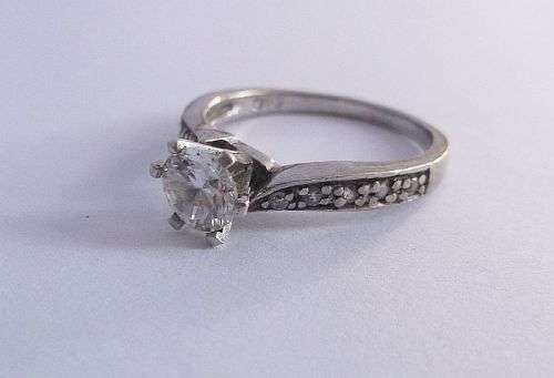 A BEAUTIFUL SOLID STERLING SILVER ENGAGEMENT STYLE RING SET WITH FACETED CLEAR STONES