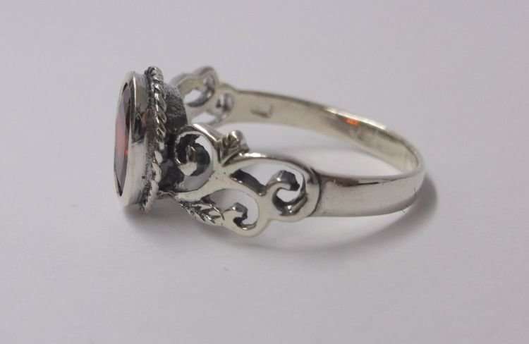 AN EYE CATCHING SOLID STERLING SILVER RING SET WITH A FIERY RED FACETED STONE ..,.TE PRAGTIG !!!