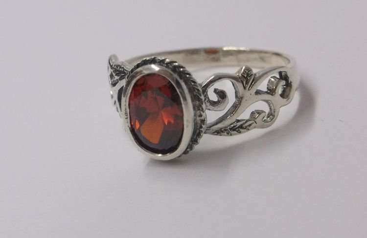 AN EYE CATCHING SOLID STERLING SILVER RING SET WITH A FIERY RED FACETED STONE ..,.TE PRAGTIG !!!