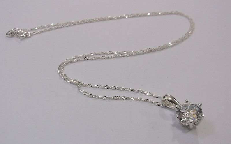 AN ELEGANT STERLING SILVER PENDANT WITH FACETED CLEAR STONE PLUS A 45 CM STERLING SILVER NECKLACE