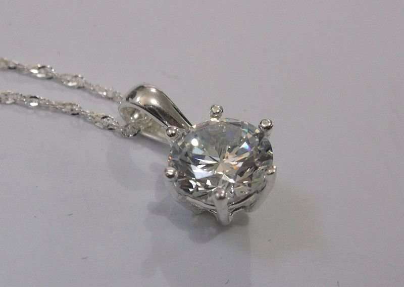 AN ELEGANT STERLING SILVER PENDANT WITH FACETED CLEAR STONE PLUS A 45 CM STERLING SILVER NECKLACE