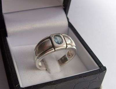 A SOLID QUALITY STERLING SILVER RING SET WITH A FACETED BLUE STONE - LOOKS LIKE AQUAMARINE
