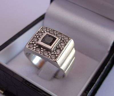 AN EYE CATCHING STERLING SILVER RING SET WITH MULTIPLE FACETED STONES