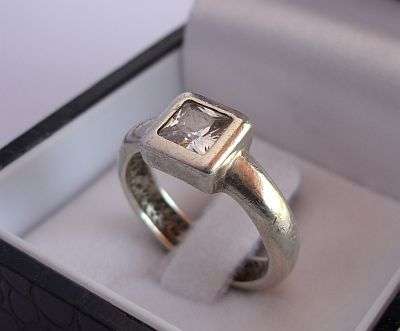 A SOLID QUALITY STERLING SILVER RING SET WITH A FACETED SQUARE CZ STONE