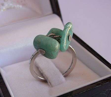 A VERY UNUSUAL & ATTRACTIVE SILVER DESIGNER TYPE RING WITH GREEN STONES