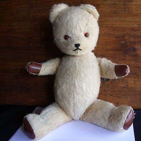 A VINTAGE TEDDY BEAR WITH GLASS EYES