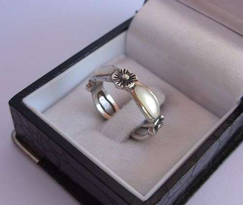 AN EYE CATCHING STERLING SILVER RING SET WITH MOTHER OF PEARL LOOK INSETS !! VERY SWEET !!