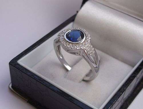 WHAT A TREASURE !! A SOLID STERLING SILVER RING SET WITH A FACETED BLUE STONE & CZ STONES !!!