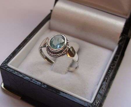 AN EYE CATCHING STERLING SILVER RING SET WITH A FACETED BLUE STONE - SIZE M AND A HALF