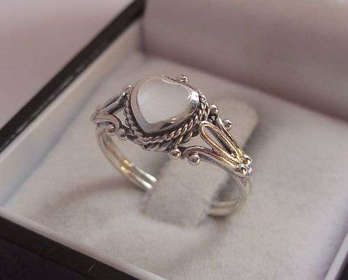 A MARVELLOUS STERLING SILVER RING SET WITH A MOTHER OF PEARL LOOK HEART - SIZE K