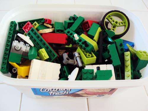 Tub filled with Lego and other building blocks, even a battery piece