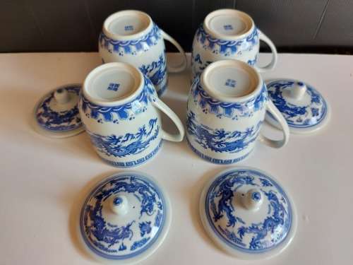 SET OF FOUR DRAGON MOTIF ORIENTAL LIDDED MUGS WITH THE MAKERS MARK AT THE BASE