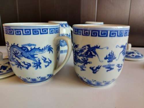 SET OF FOUR DRAGON MOTIF ORIENTAL LIDDED MUGS WITH THE MAKERS MARK AT THE BASE