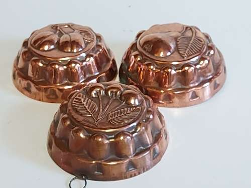 THREE VINTAGE COPPER JELLY MOULDS WITH A FRUIT MOTIF