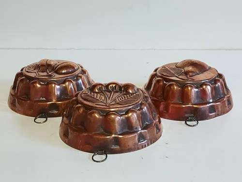 THREE VINTAGE COPPER JELLY MOULDS WITH A FRUIT MOTIF