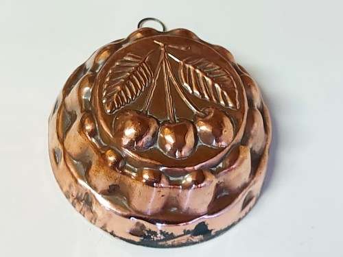 THREE VINTAGE COPPER JELLY MOULDS WITH A FRUIT MOTIF