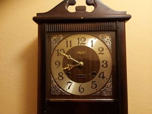 VINTAGE RHYTHM 30 DAY WALL CLOCK IN A WOODEN CASING, WITH KEY AND PENDULUM AND WORKING