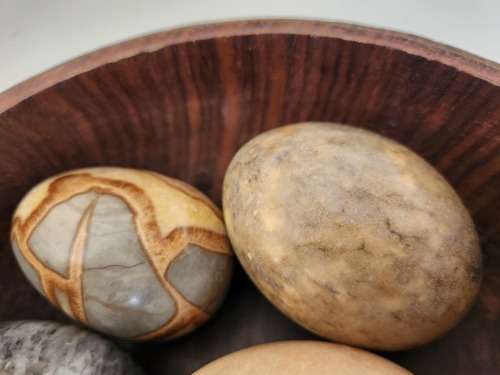 6 HIGHLY POLISHED LARGE SEMI-PRECIOUS GEMSTONE EGGS IN A CARVED WOODEN BOWL
