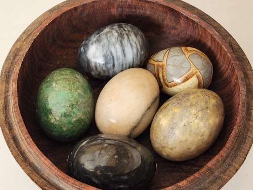 6 HIGHLY POLISHED LARGE SEMI-PRECIOUS GEMSTONE EGGS IN A CARVED WOODEN BOWL