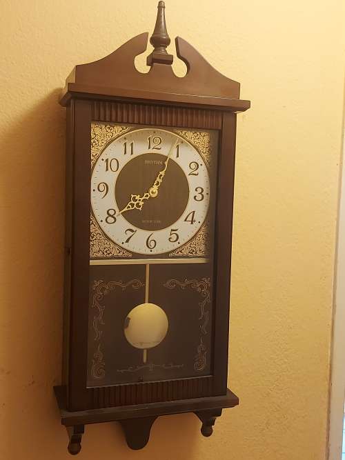 VINTAGE RHYTHM BATTERY STRIKE WALL CLOCK IN A WOODEN CASING WITH A PENDULUM, NOT TESTED