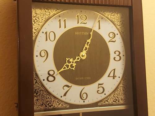 VINTAGE RHYTHM BATTERY STRIKE WALL CLOCK IN A WOODEN CASING WITH A PENDULUM, NOT TESTED