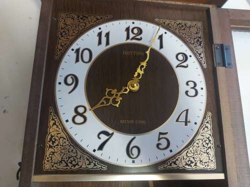 VINTAGE RHYTHM BATTERY STRIKE WALL CLOCK IN A WOODEN CASING WITH A PENDULUM, NOT TESTED
